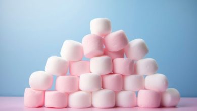 Pink and white marshmallows stacked high, tempting with their sugary sweetness. A delightful treat for those with sugar cravings